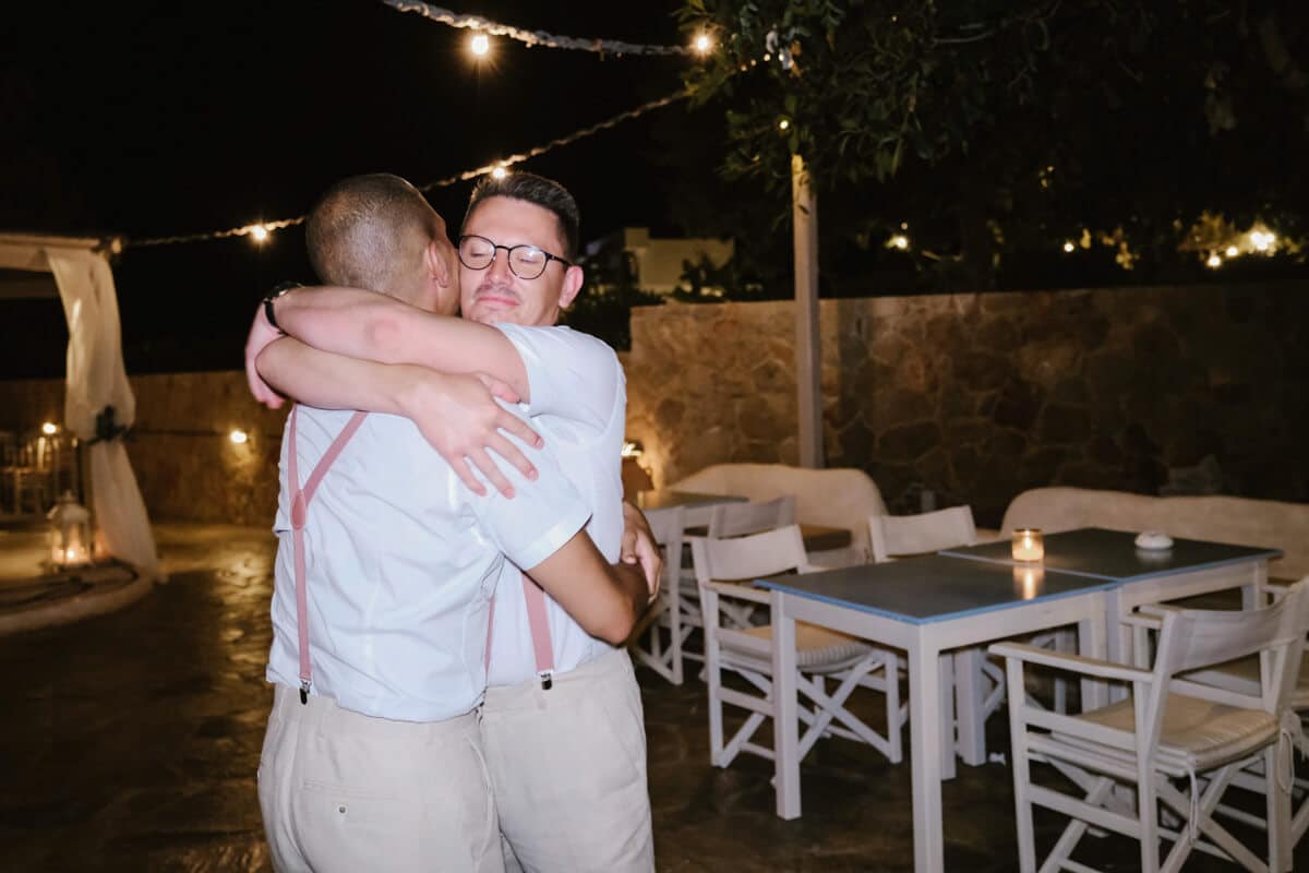 LGBTO+ couple hug at wedding reception party in Rhodes